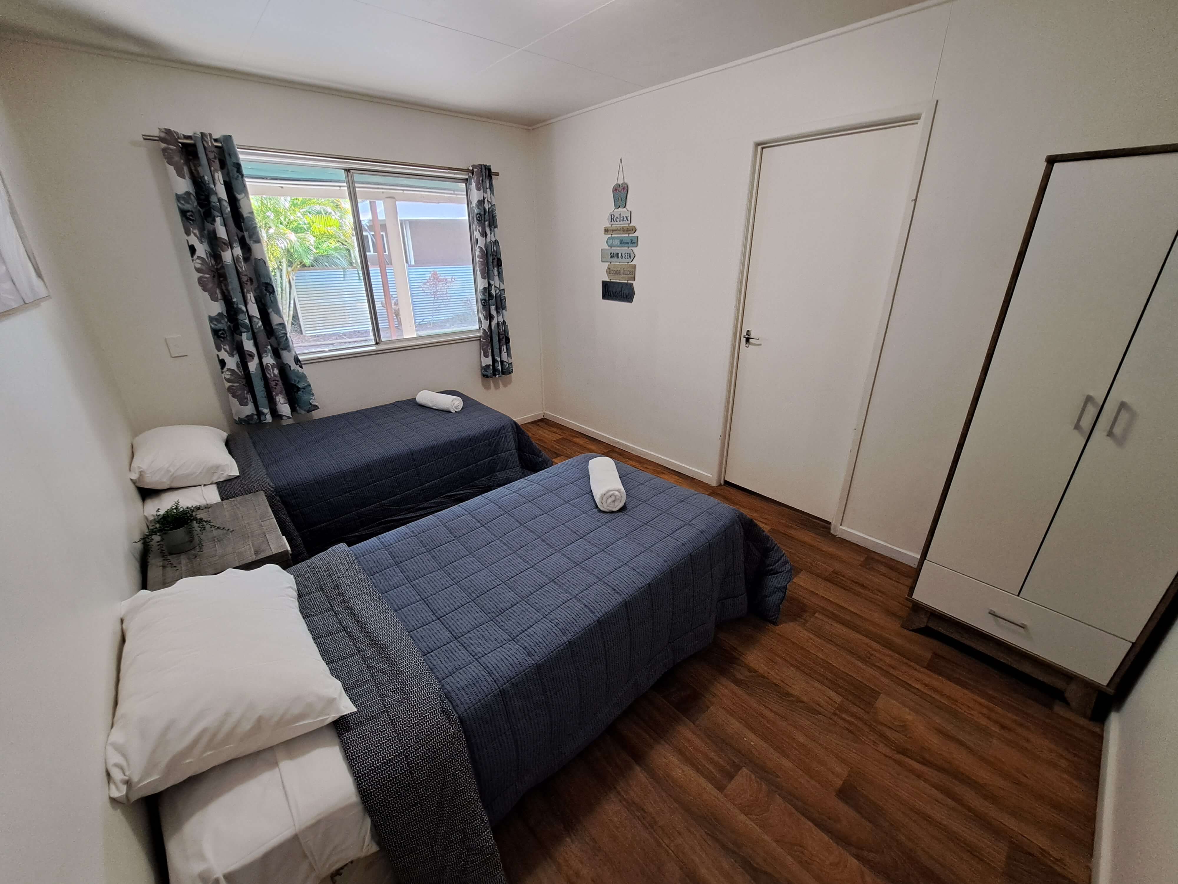 Bedroom with 2 single beds in holiday home at Castaways Moreton